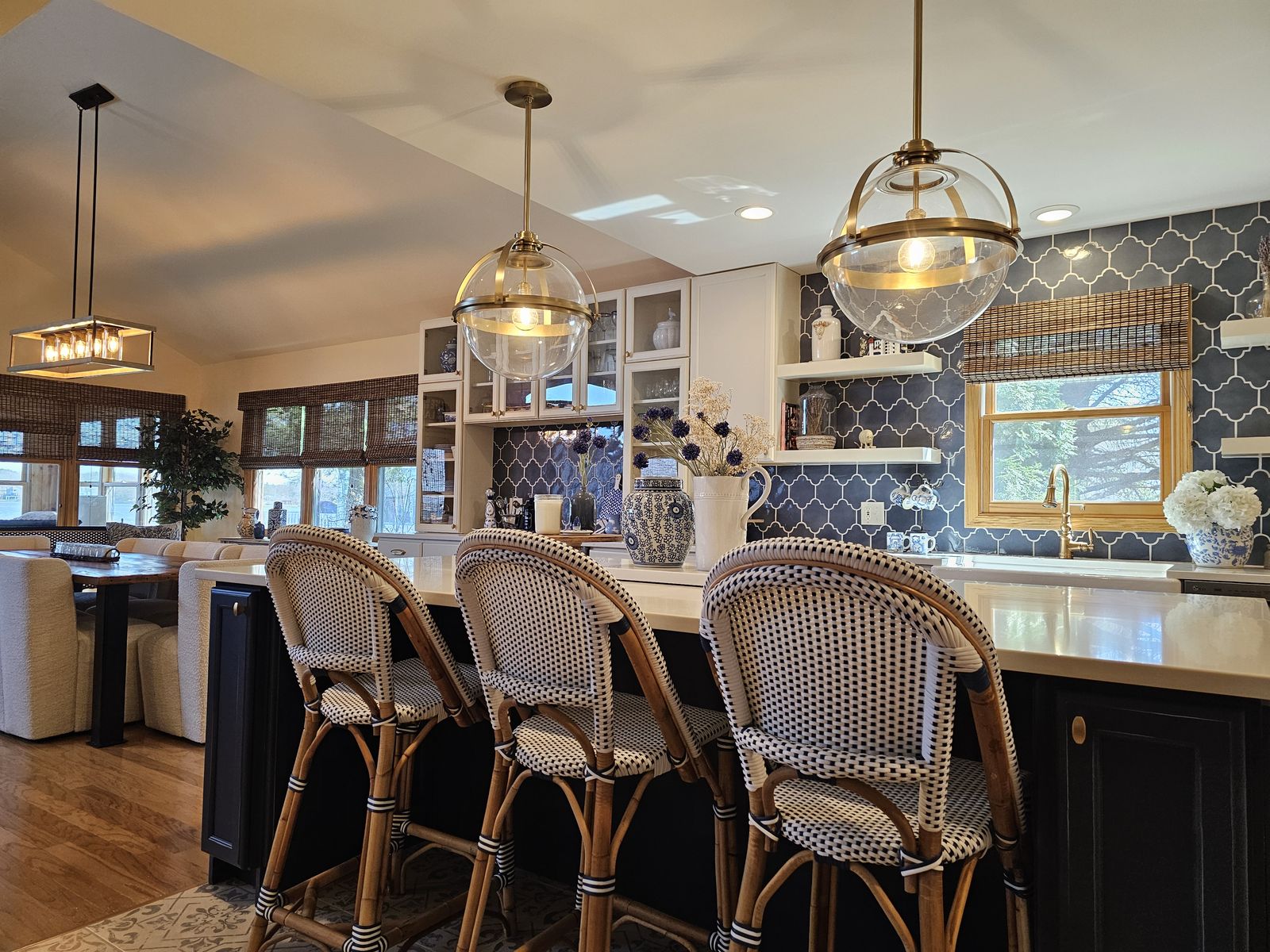 Woven bistro counter stools along the navy island