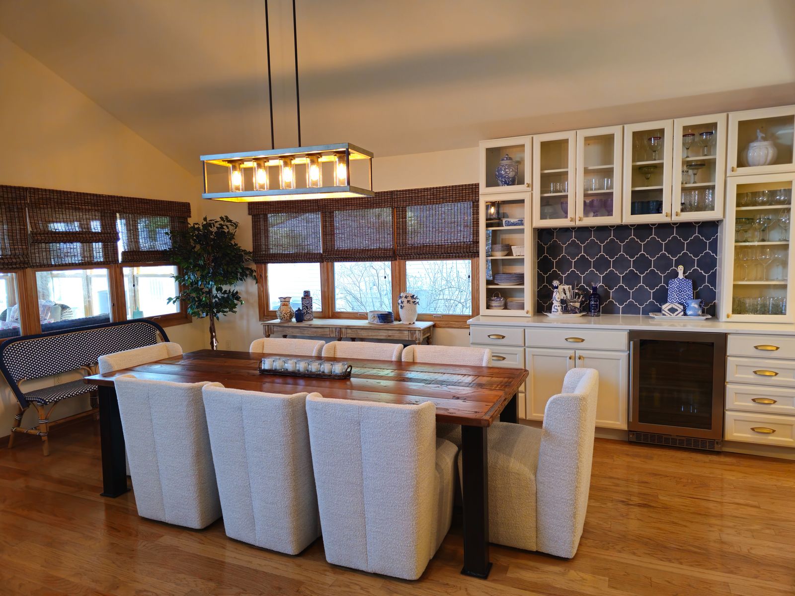 Reclaimed wood dining table beneath a linear lantern fixture