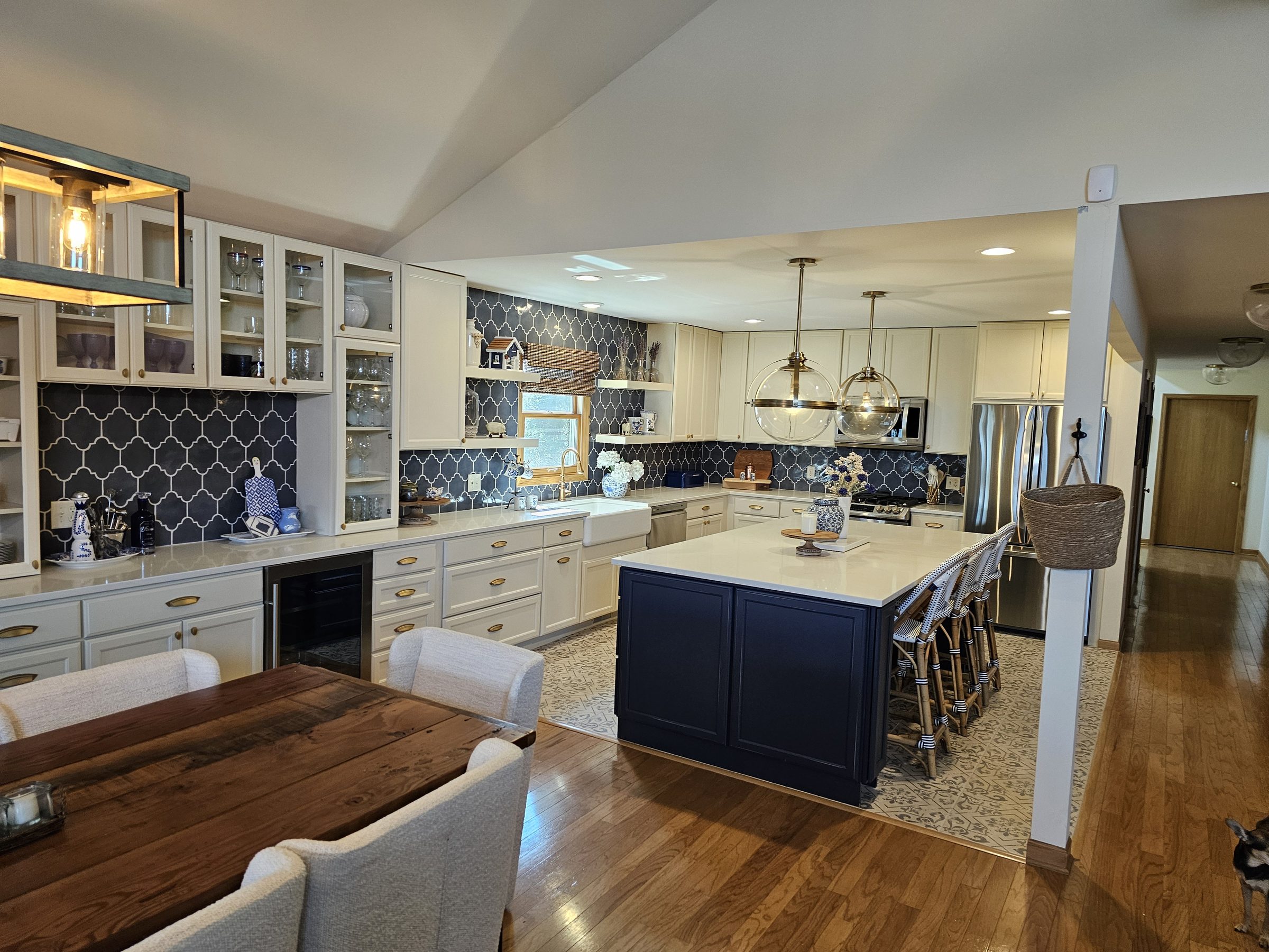 Twin Lakes kitchen with navy island, arabesque tile backsplash and open dining room